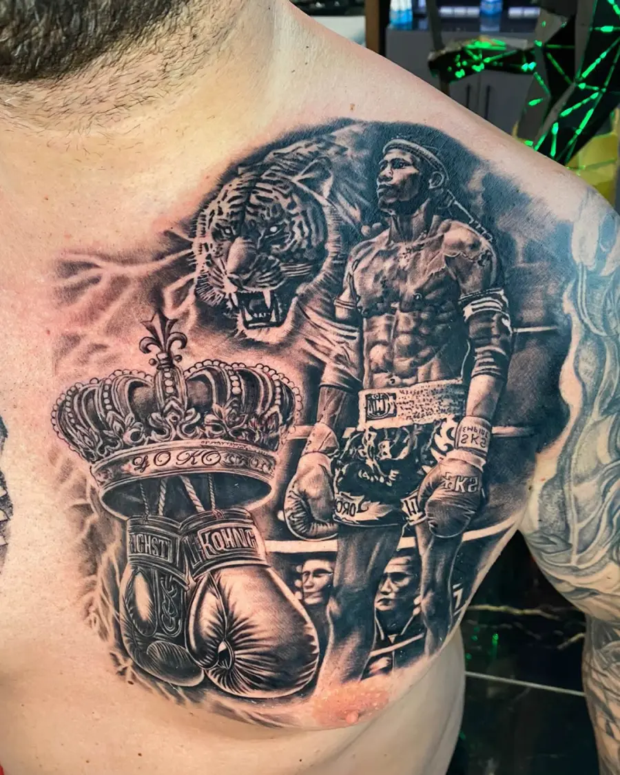 Ramses Ink atölyesinde yapılmış siyah-gri realistik göğüs dövmesi — boksör, kaplan ve taç kompozisyonu